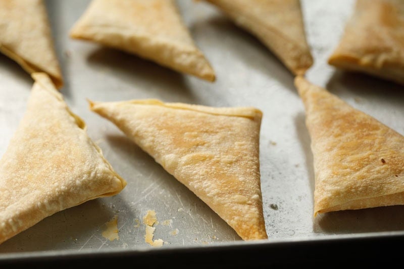 Golden brown triangular baked onion samosa.