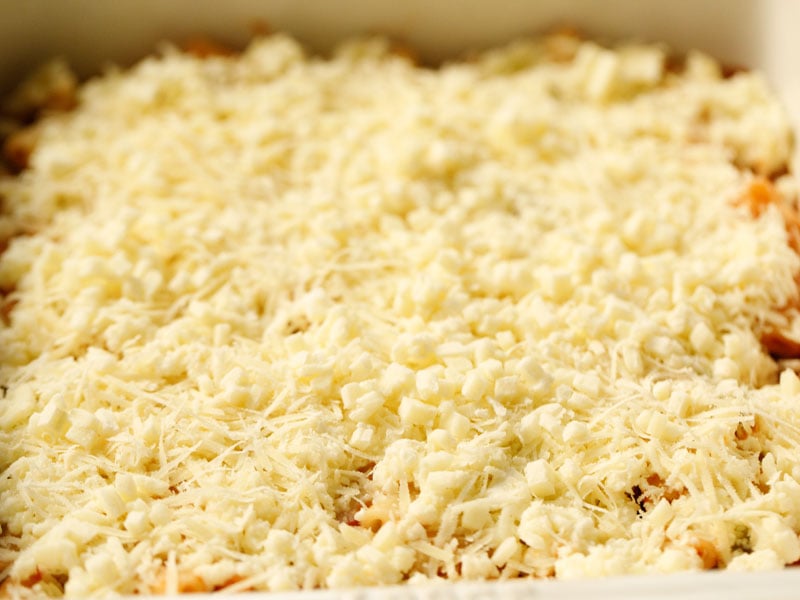 mozzarella and parmesan spread over ricotta mixture for baked ziti recipe