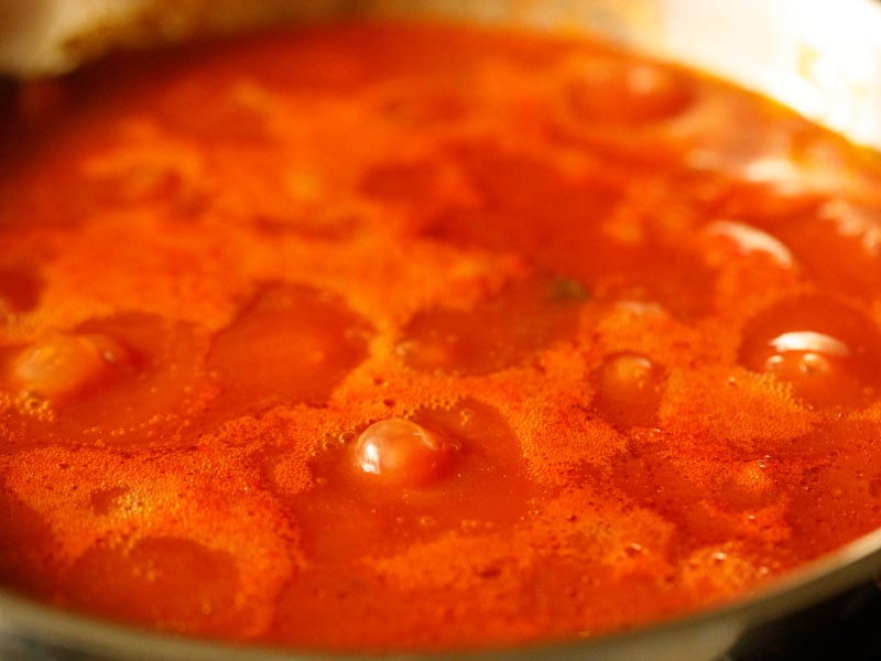 tomato sauce in a pan as it begins to bubble