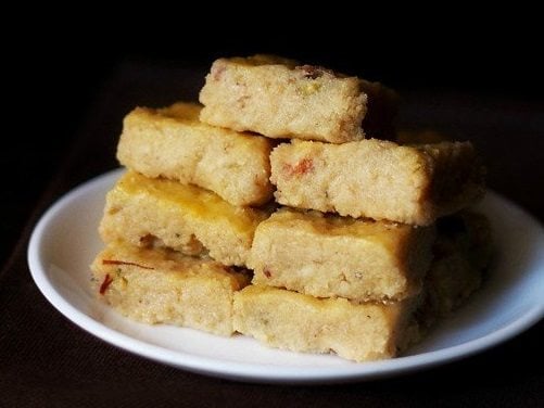 barfi pieces stacked on plate.