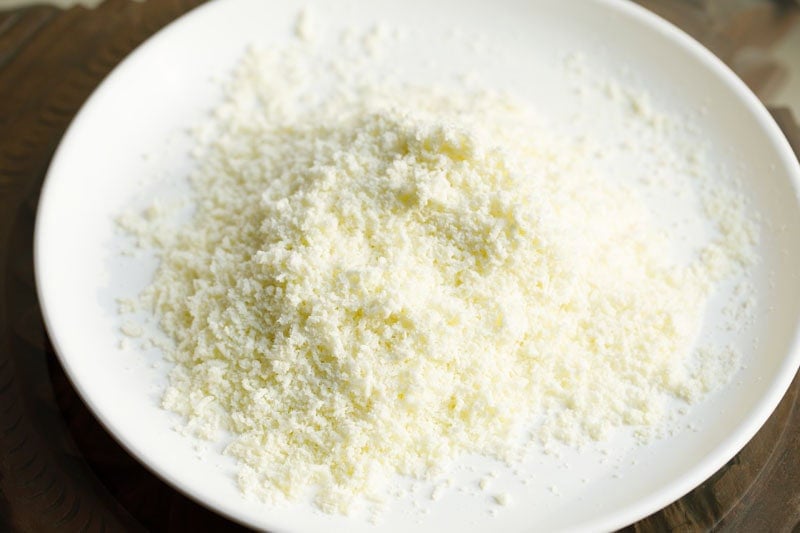 Grated khoya on a white plate.