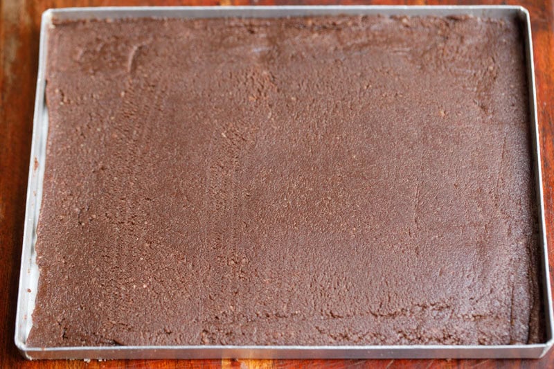 Smooth chocolate barfi mithai in a tray.