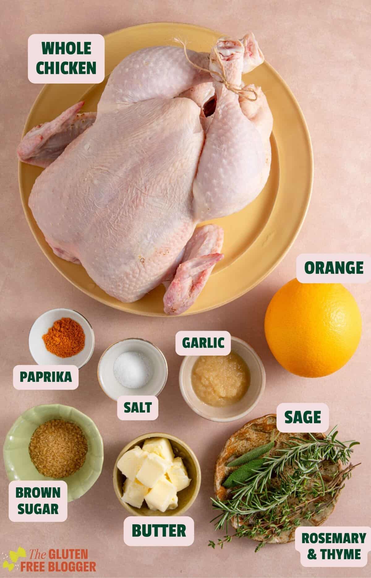 Ingredients for a Christmas roast chicken including herbs, butter, orange and garlic.