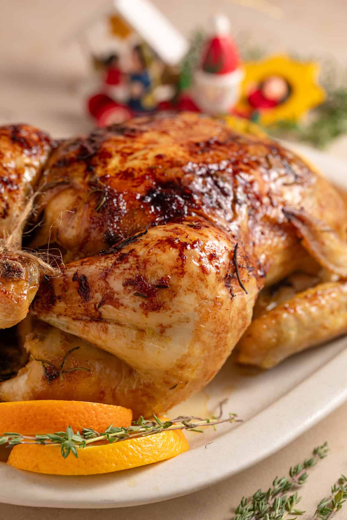  A Christmas glazed roast chicken on a serving plate.