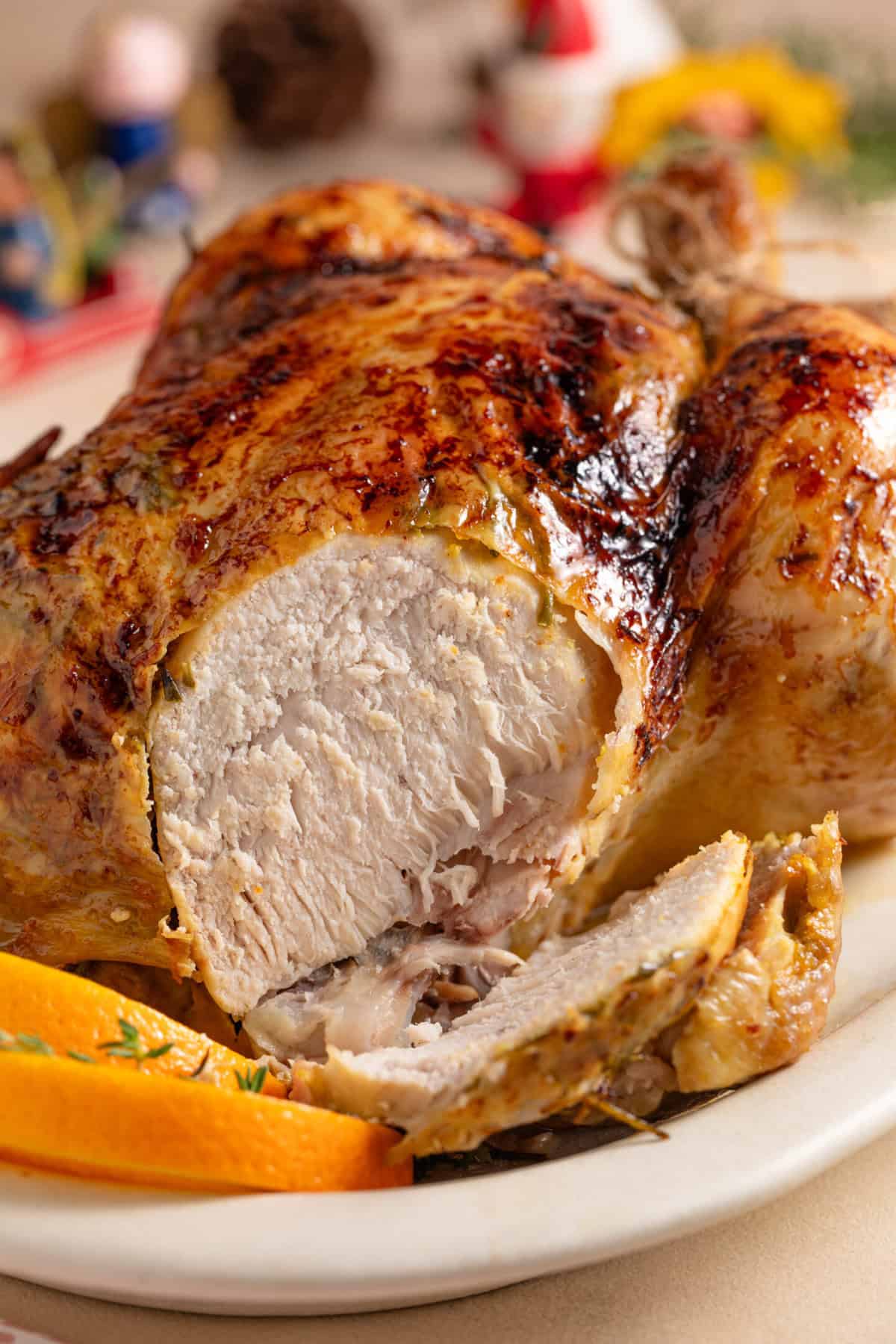 A gluten free Christmas roast chicken with a slice taken out to expose the meat.