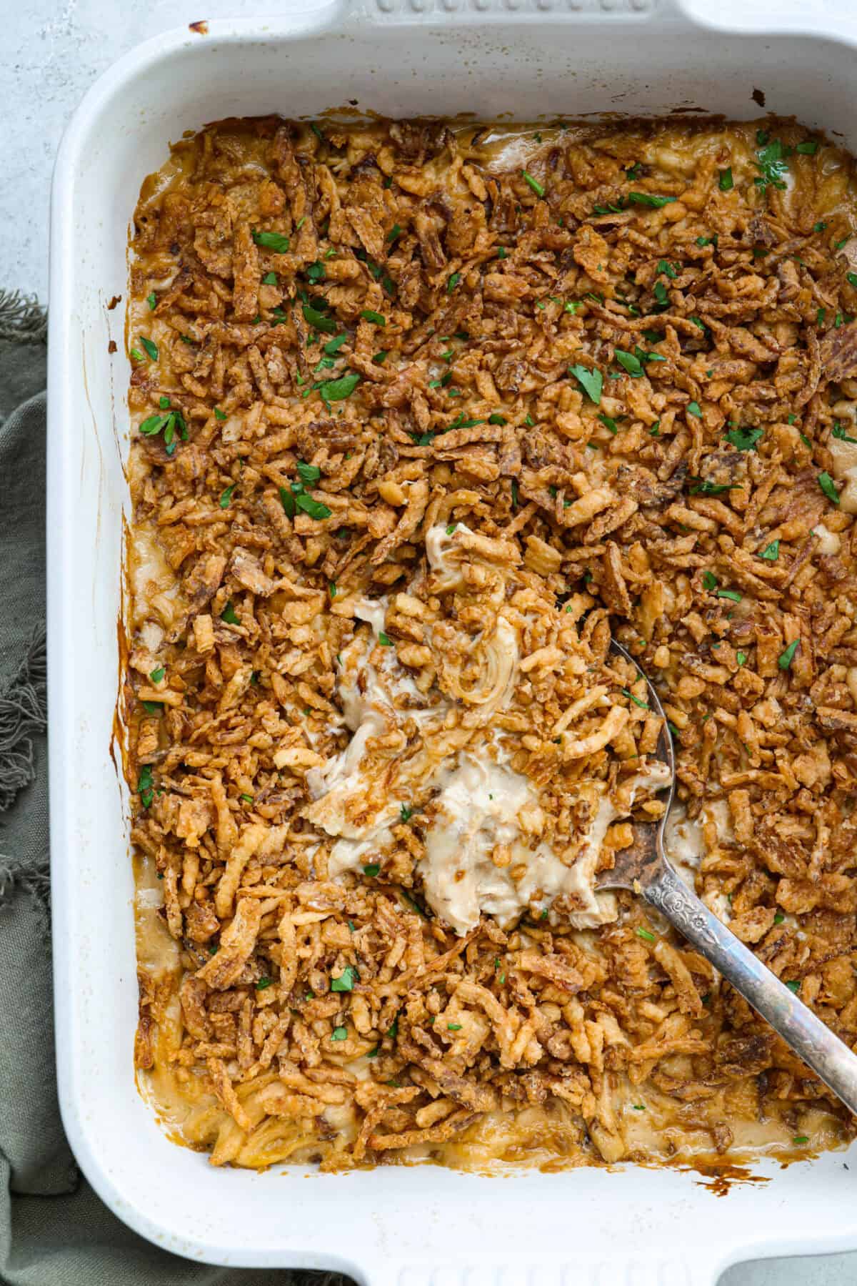 Creamy, cheesy, and packed with shredded chicken, this French onion chicken casserole is comfort food at its best! Inspired by French onion soup and dip, it’s topped with crispy fried onions for a crunchy finish. Overhead shot of baked French onion chicken casserole in a baking dish.
