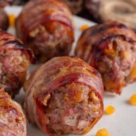 Close up of a plate of bacon-wrapped gluten free stuffing balls with chopped apricots.