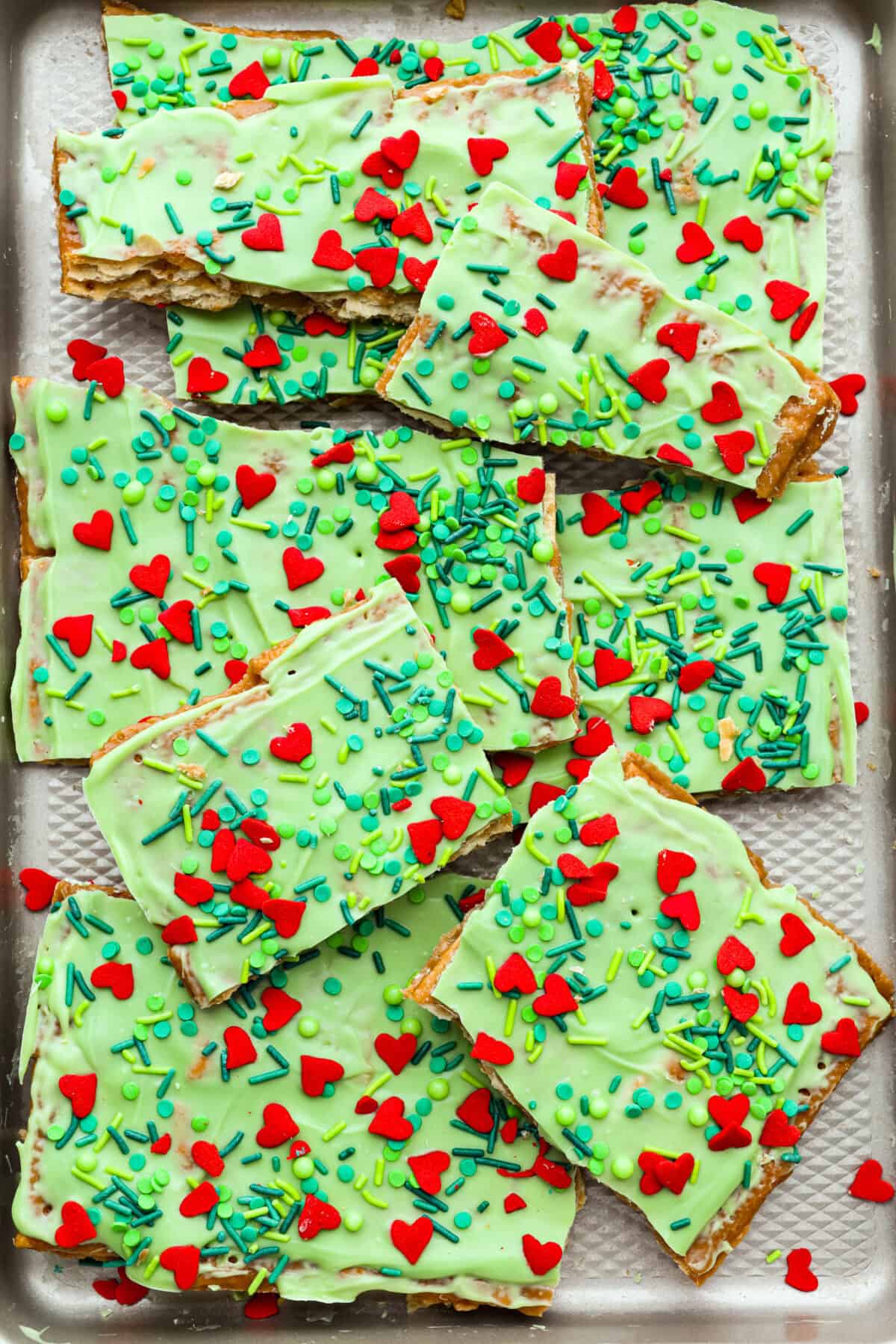 If you want a quick, crunchy treat with a bit of holiday mischief, this Grinch Christmas Crack is it. Sweet, salty, and totally addictive. My classic Christmas Crack is always a hit, but this version brings all the Grinchy fun! Overhead shot of Grinch Christmas crack broken into pieces.