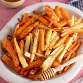 A large plate filled with roast carrots and parsnips.