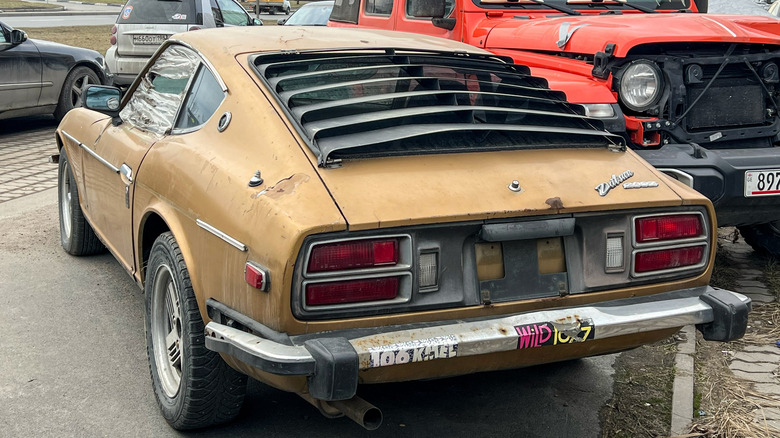 St-Petersburg, Russia, March 3, 2025: Detail of a classic brown Japanese Datsun 260 Z, parked at the street. Nissan 260 Z sport car. Classic Datsun 260Z sports car parked on street, part of the body.