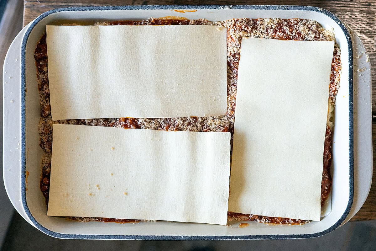 step-by-step lasagna layers: sauce, noodles, ricotta, mozzarella