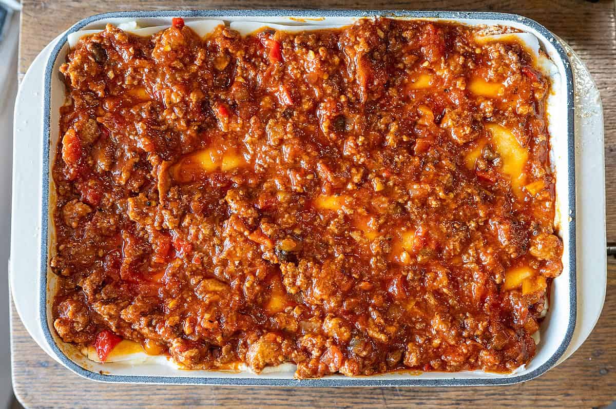 step-by-step lasagna layers: sauce, noodles, ricotta, mozzarella