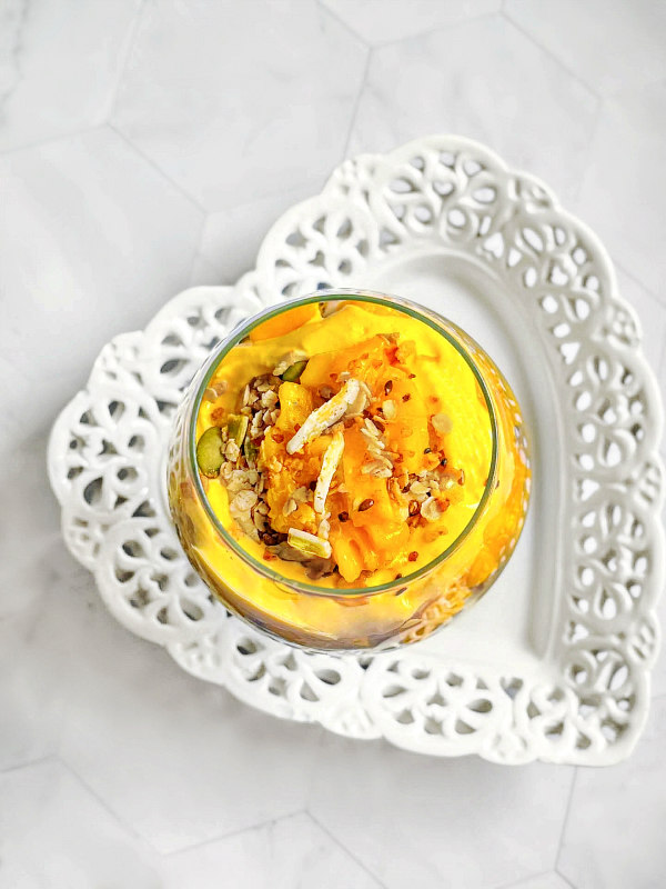 mango yogurt granola parfait on a white table