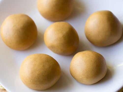 moong dal ladoo served on a white plate.