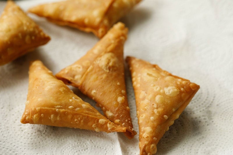 Golden brown triangular fried patti samosa.