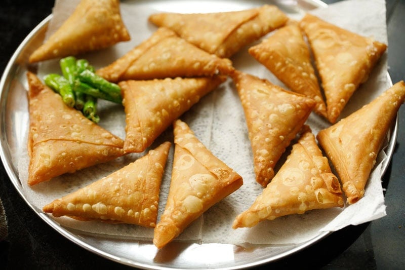 Crispy golden-brown triangular onion samosa.