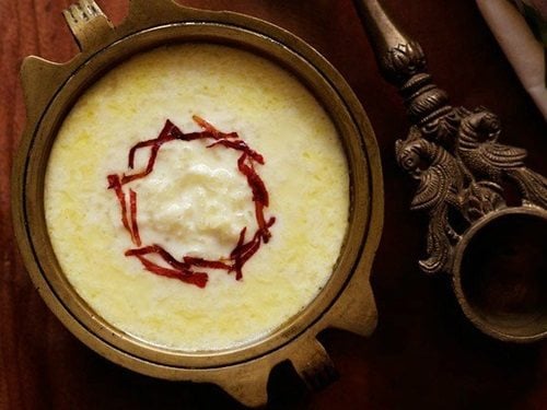 paal payasam garnished with dried rose petal chiffonade in a brass bowl.