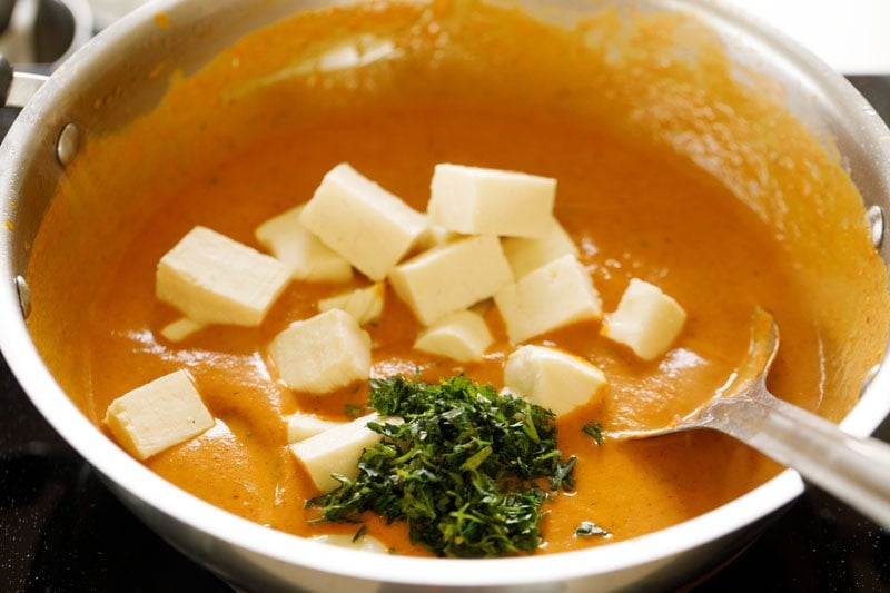 Paneer cubes and chopped coriander on top of the gravy.