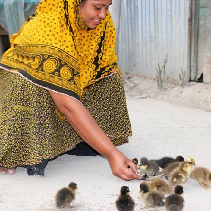 woamn feeding ducklings as a symbolic charitable baby gift