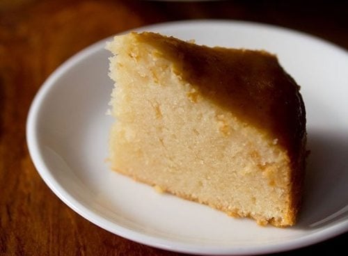closeup photo of thick slice of pressure cooker cake on white plate.