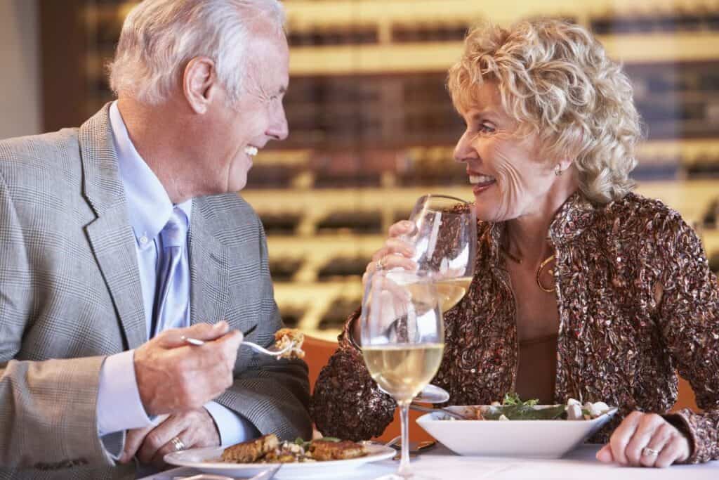 Older couple enjoying dinner with white wine — UK Restaurant Gift Vouchers gift idea for grandparents