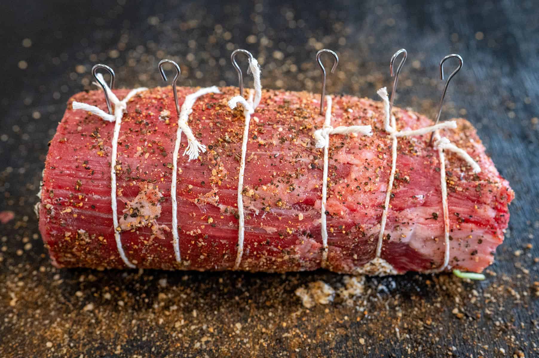 Rolled up steak pinwheel secured with twine.