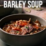 A bowl of slow cooker beef and barley soup sits on a table, topped with herbs; text above reads "How to Make Slow Cooker Beef and Barley Soup.