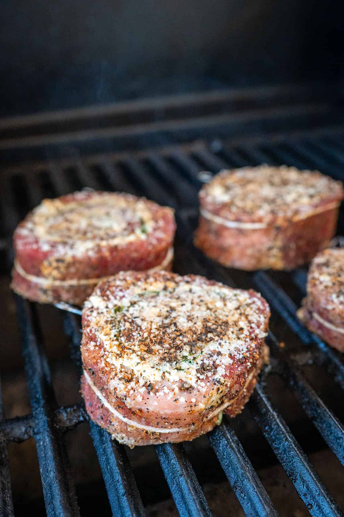 raw steak pinwheels on grill.