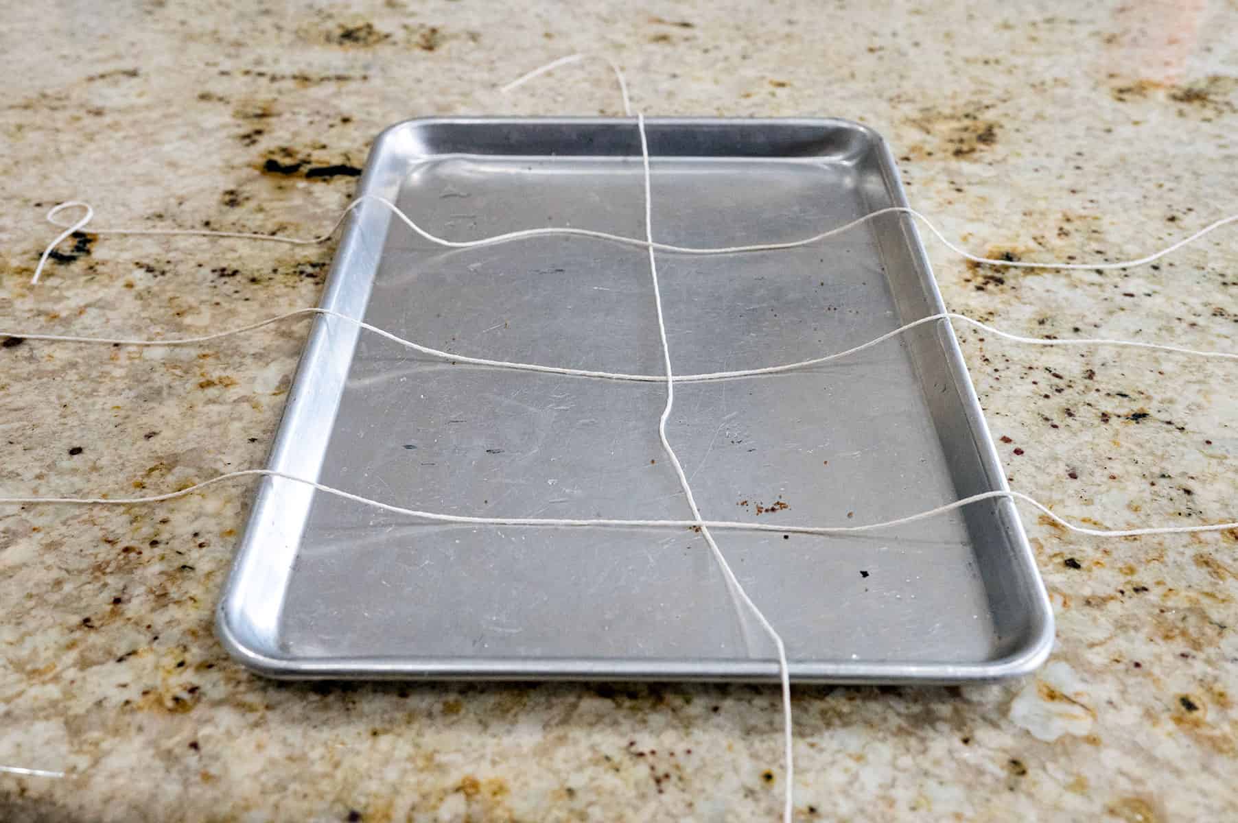 Sheet pan with strings of twine.