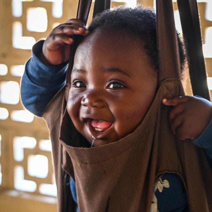 baby being weighed in a fabric scale