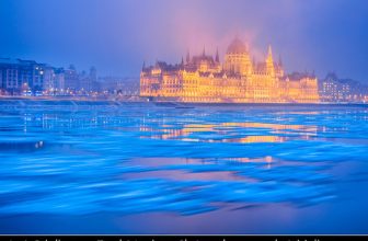 Hungary – Budapest – Hungarian Parliament Building – Iconic landmark reflected at Danube River full of floating ice