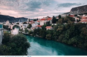 View on the city of Mostar with the Stari Most old bridge and the Neretva river surrounded by mountains in Bosnia and Herzegovina.