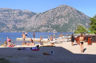 Secluded Morinj Beach with a backdrop of mountains in Kotor Bay