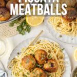 Plates of spaghetti topped with chicken piccata meatballs, garnished with capers and parsley, with lemon slices and a skillet of meatballs in the background.