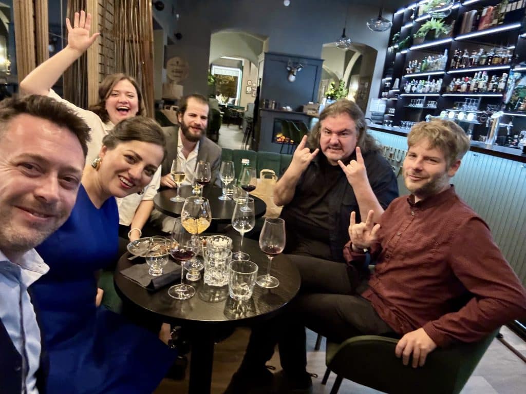 Kate and Charlie and a group of friends looking drunk around the table.