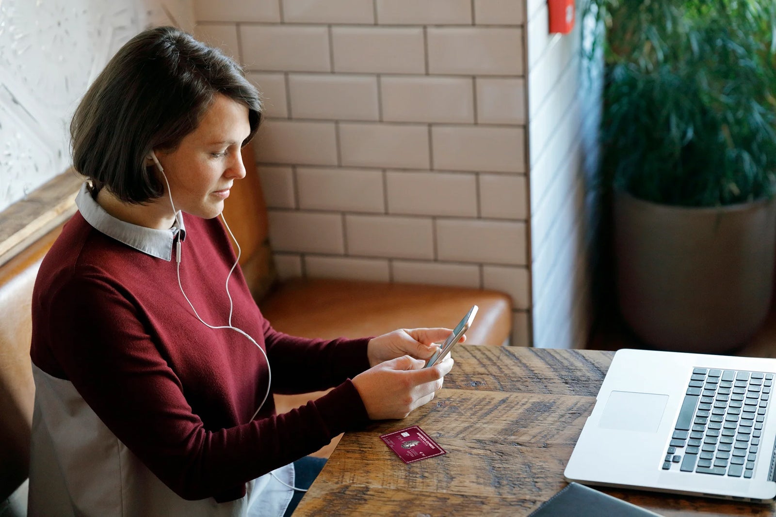 woman sitting at a table looking at her phone