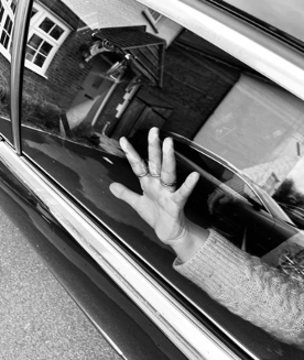 A hand pressed against a car window