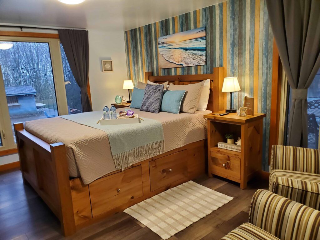 The Cottage room at The Blue Bruce has a beachy feel offering lots of room, a large bed and 2 chairs to relax on