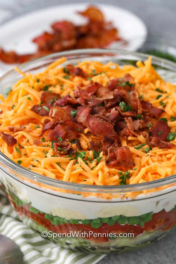 The perfect layered salad in a glass bowl garnished with parsley