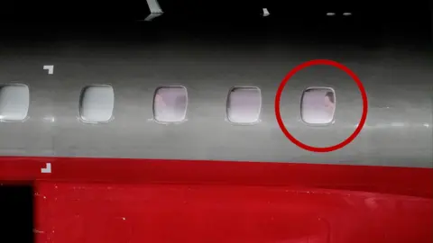 Amanda Pedersen Giske/NTB via Reuters A red and white plane where Machado can be seen at the last window, with a graphic red circle superimposed around it