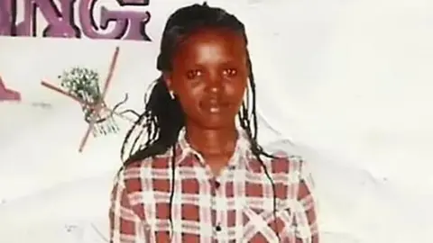 Reuters A portrait of Agnes Wanjiru with braided hair, dressed in a checked shirt