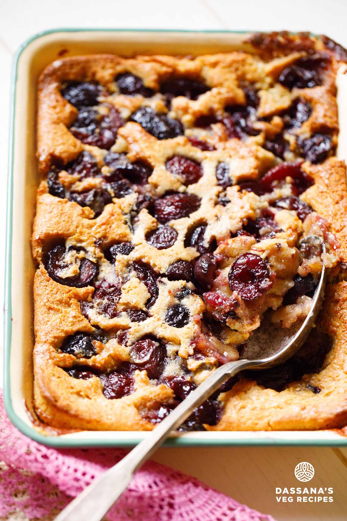 Baked cherry cobbler with spoon.