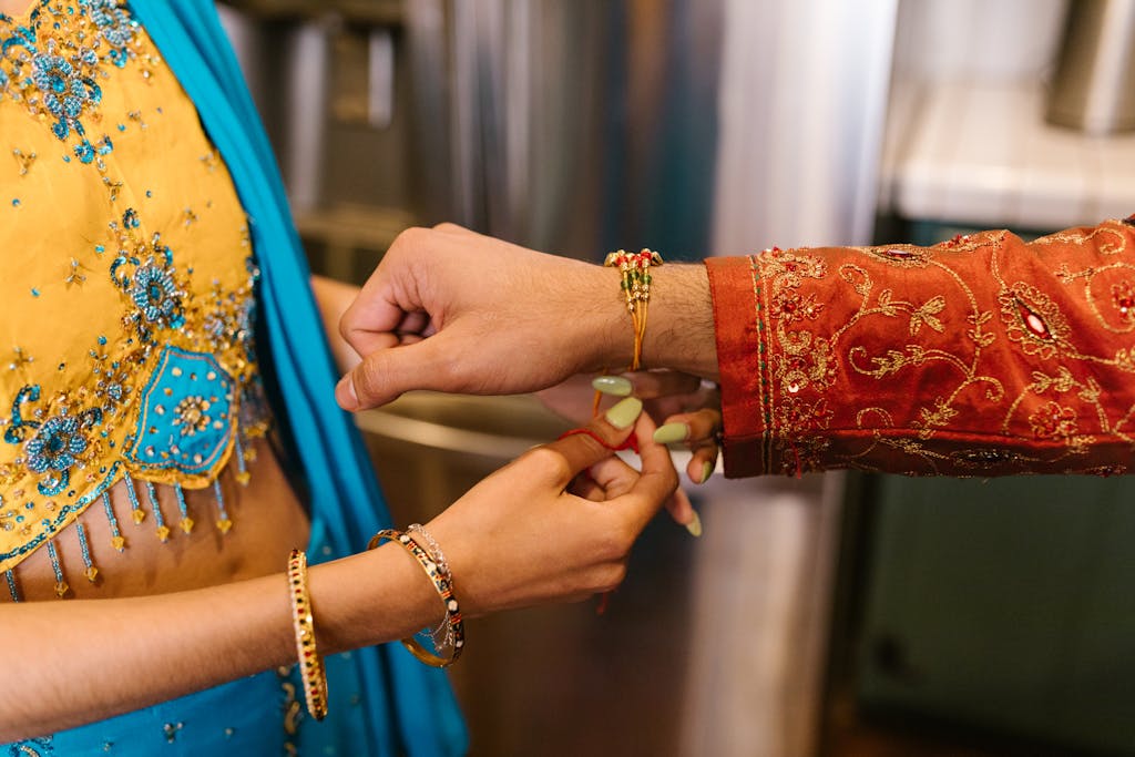 Close-up of a woman tying a rakhi on a man's wrist giving the impression of a free gift and then scammer will ask for money