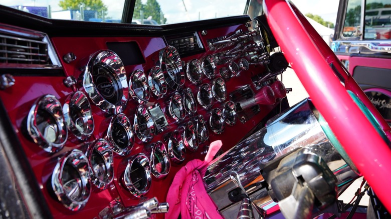 A semi truck dashboard with several different gauges.