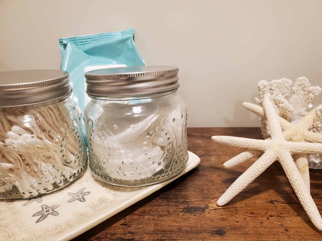Each guest room is stocked with personal amenities such as qtips and makeup remover pads displayed in a beachy theme
