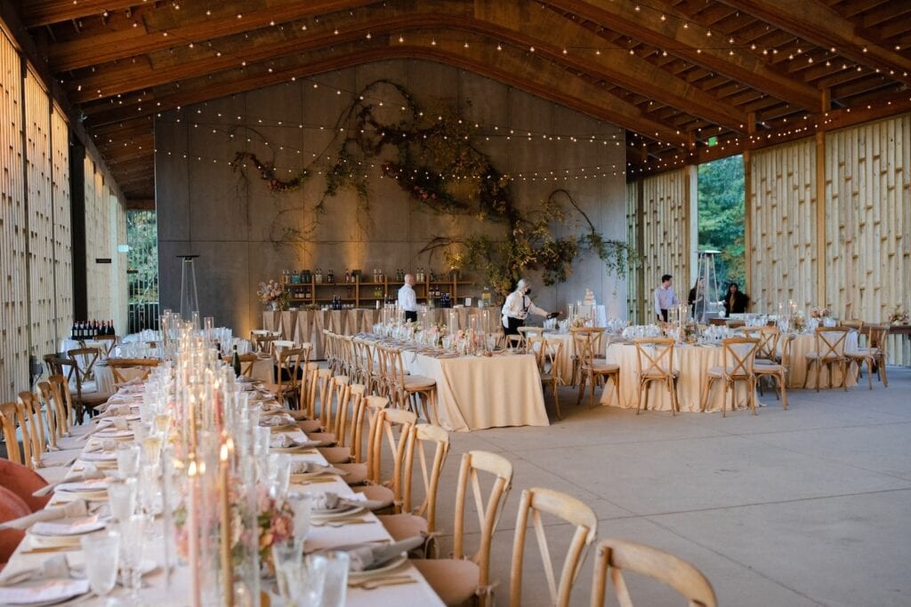 Large barn-like structure decorated with long tables for a wedding reception