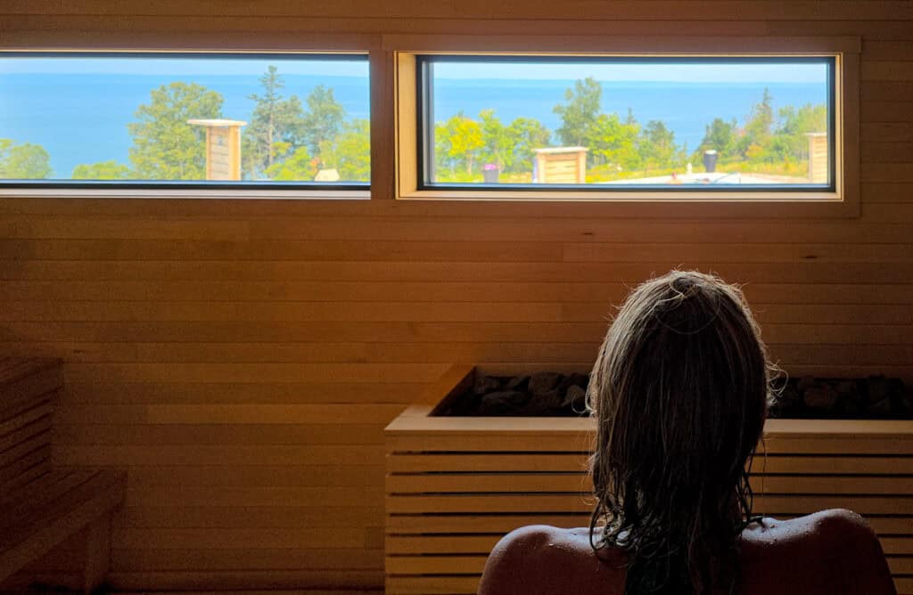 woman in dry sauna with views of bay of fundy out window