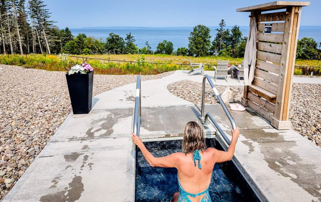 woman in nordic cold plunge pool overlooking bay of fundy at saltair spa