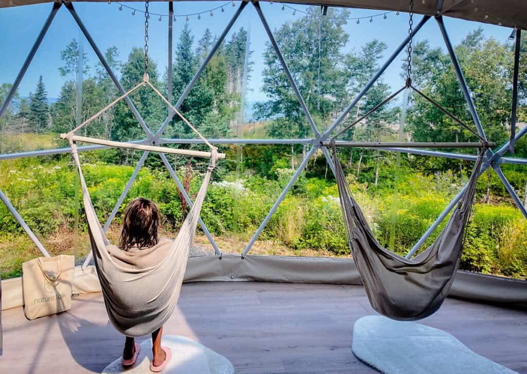 woman in hammocks with forest views